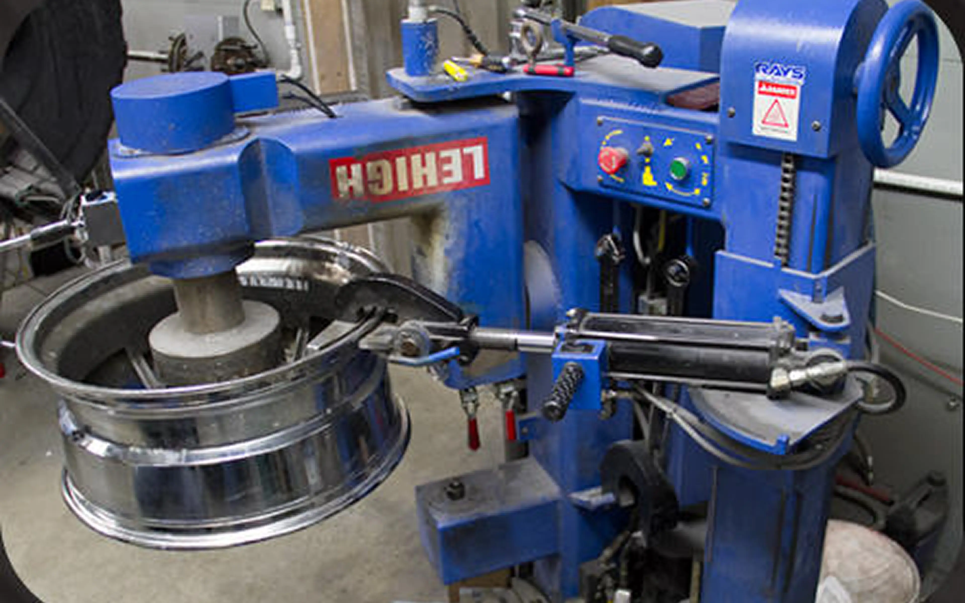 Machine repairing a metal wheel rim.