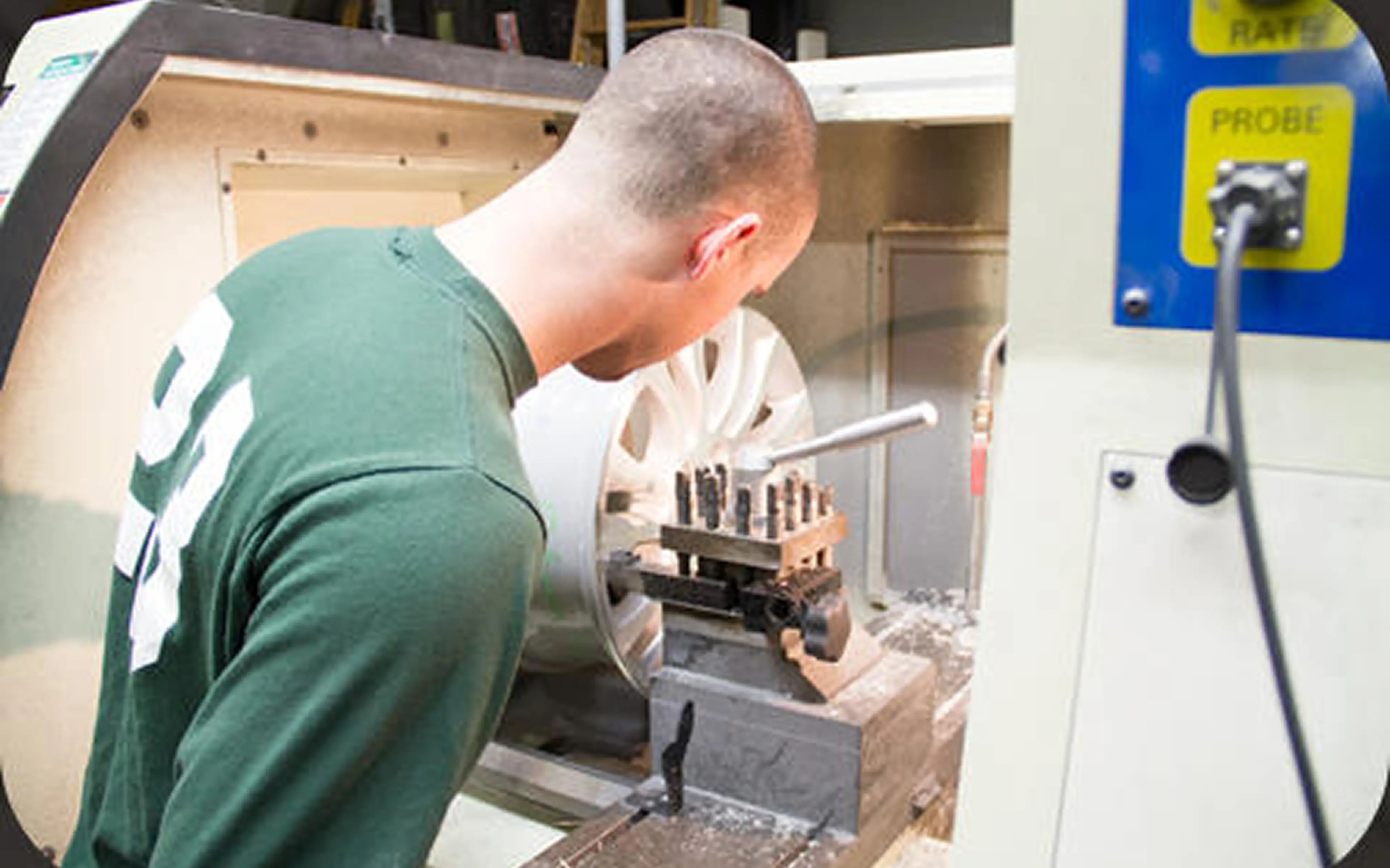 Man operating industrial milling machine.