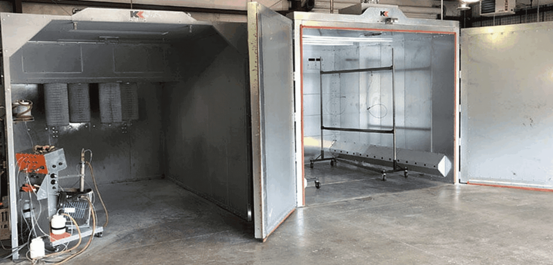 Industrial spray booth with open doors.